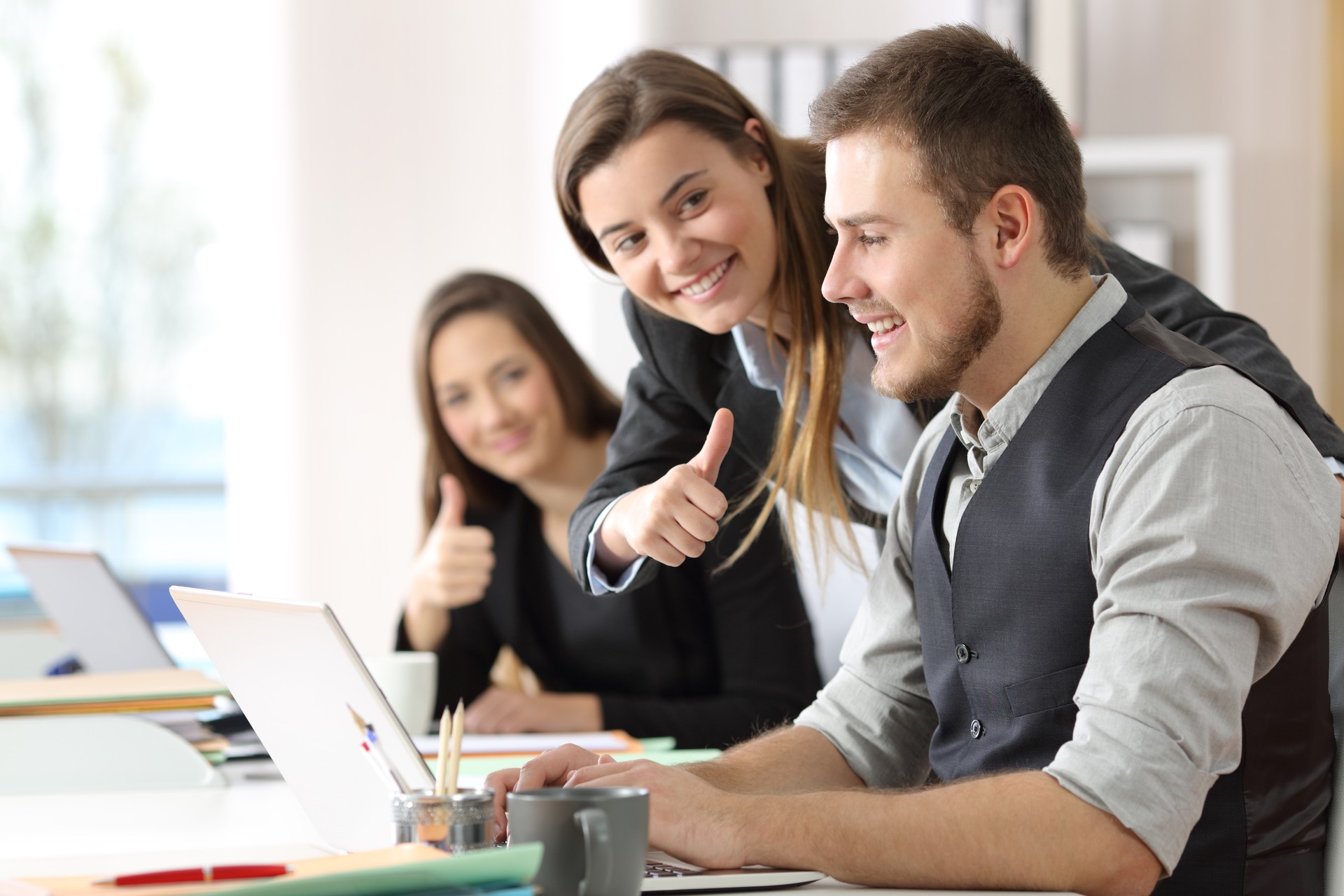 Colleagues congratulating to a motivated worker at office